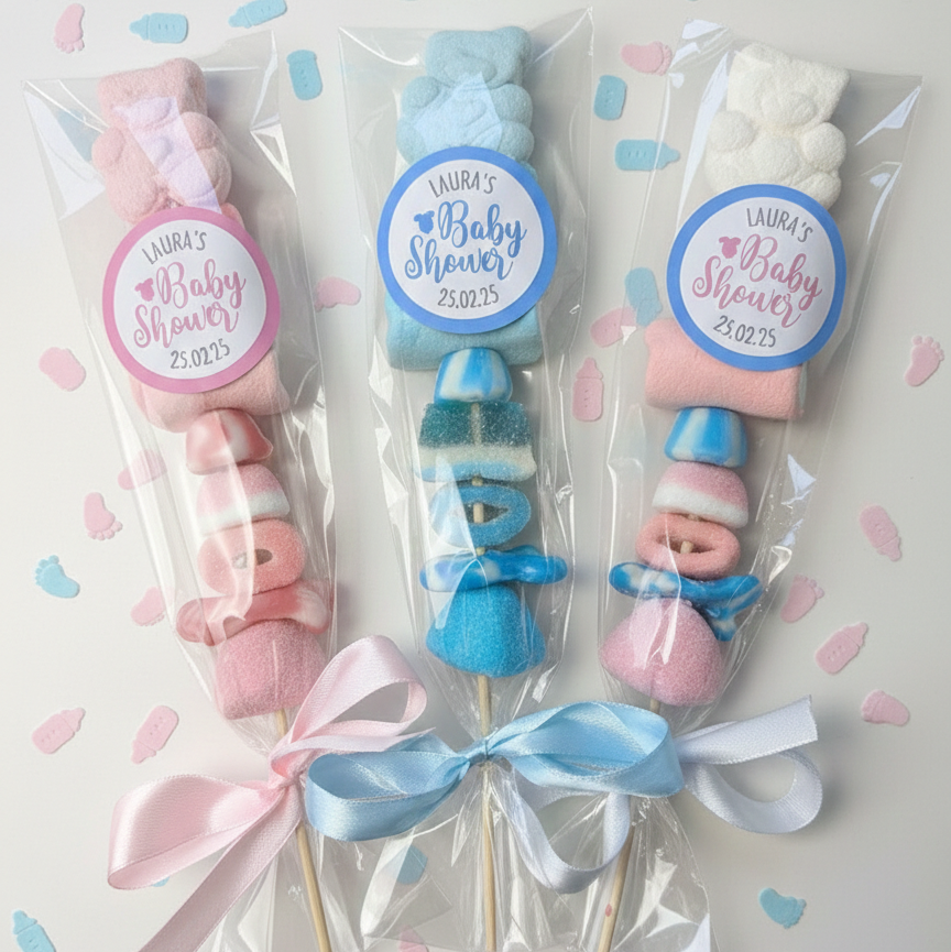 Baby shower favor items with pink and blue ribbons and personalized labels on a light background.